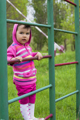 Happy little girl climbing on outdoor playground