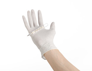 doctor's hand in white gloves holding a thermometer
