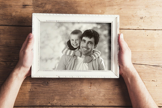 Picture frame with family photo on a wooden background.