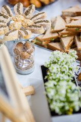Several types of sandwiches on a table decorated with flowers.