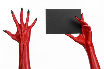 Red devil hand with black nails holding a blank black card