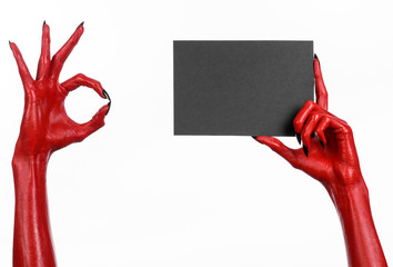 Red devil hand with black nails holding a blank black card