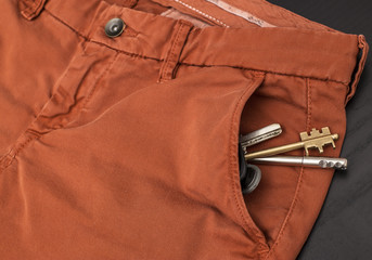 A bunch of keys is in the pocket of trousers in red