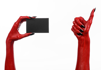 Red devil hand with black nails holding a blank black card
