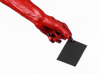 Red devil hand with black nails holding a blank black card