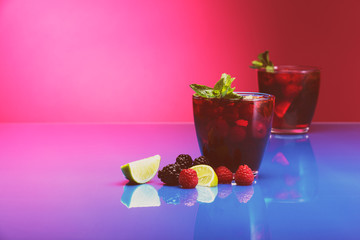 Raspberry and blackberry cocktail with mint garnish. Studio shot