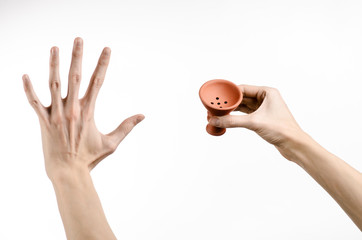 Bartender holding a clay bowl for tobacco on a white background