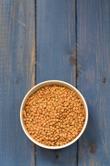 dry lentil on bowl on blue wooden backround
