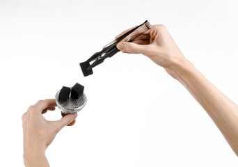 man holding a forceps with coal and puts them into a clay bowl