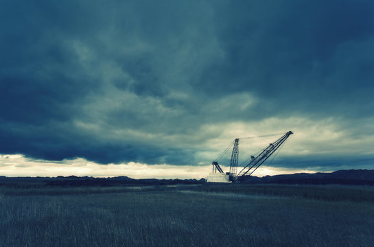 Three tall metal towers silhouetted against the sky at a drill site. 