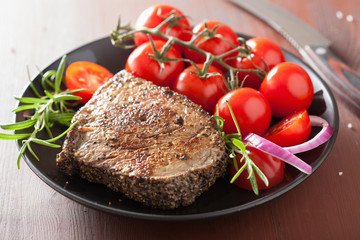 beef steak with spices and rosemary on plate