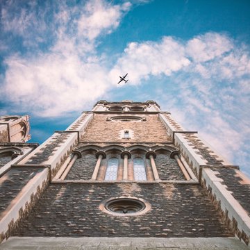United Kingdom, England, London, St Matthew's Church, Upward view of church tower with plane flying in sky above