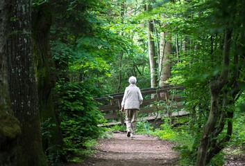 Alte Frau macht Spaziergang am Parkweg 