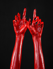 Red Devil's hands, red hands of Satan, black background isolated