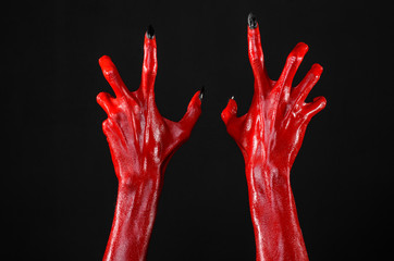Red Devil's hands, red hands of Satan, black background isolated