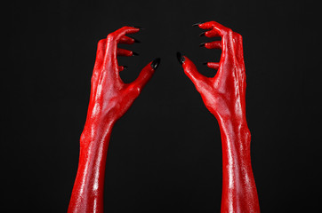 Obraz na płótnie Canvas Red Devil's hands, red hands of Satan, black background isolated