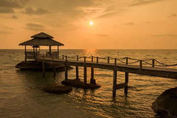 Fototapeta na wymiar Bridge on beach in sunset and sea wave in Koh Kood , Thailand