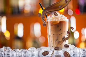 Cold coffee drink with ice, beans and splash