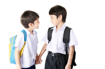 Little student sibling boy in uniform on white background