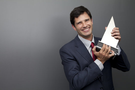 Portrait of a Smiling Businessman in a suit holding an award trophy