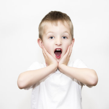 Shocked boy holding hands to face