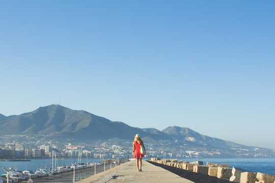 Woman In Red Walking Down Pier