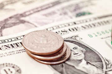 Stack of quarters on american banknotes