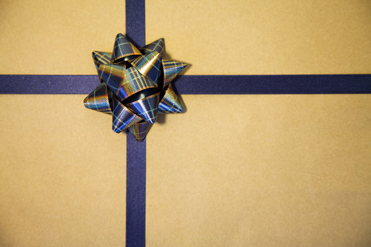 Gold gift wrapped with blue bow