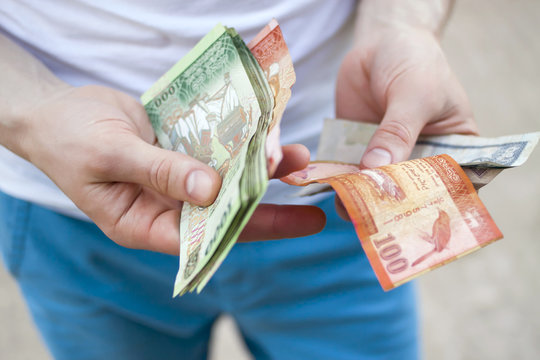Young man holding colorful banknotes