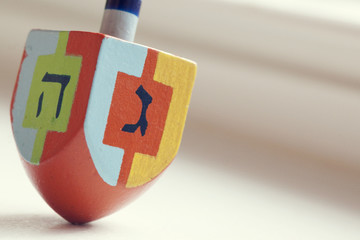 Close-up of a multi coloured dreidel against a white background