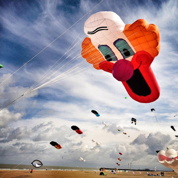 UK, Large Clown kite flying over beach