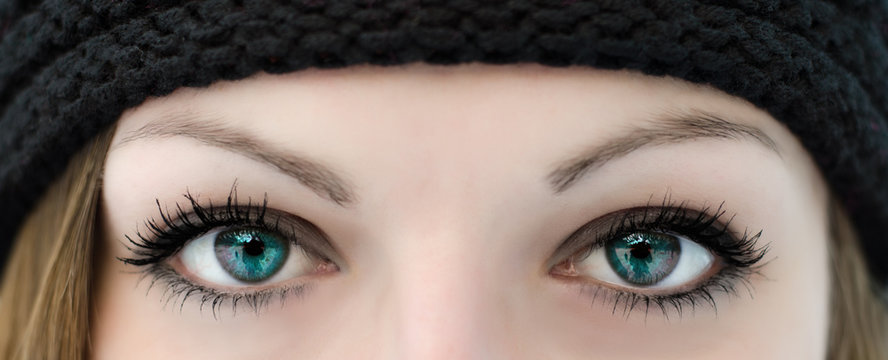 Close-up of a beautiful woman's eyes wearing eye make-up and a hat