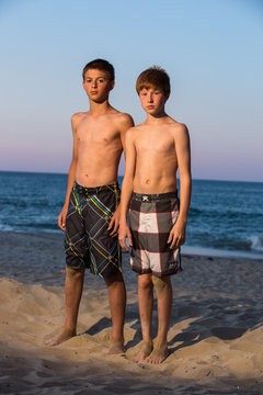USA, North Carolina, Dare County, Nags Head, Portrait of two boys (12-13) on beach at sunset