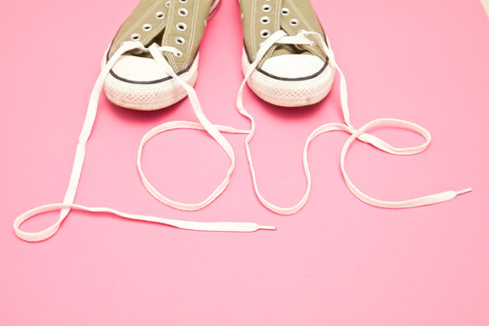 Close-up of a pair of canvas shoes with the Shoelaces spelling the word love