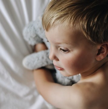 Close up of boy hugging stuffed toy