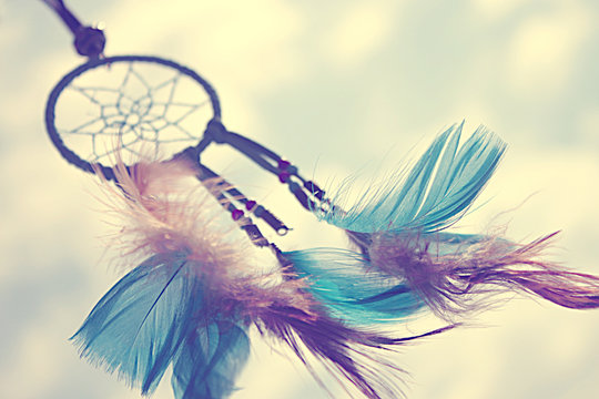Close-up of a dreamcatcher with multi coloured feathers blowing in the wind
