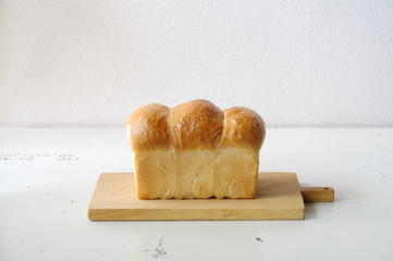 Close-Up of a Loaf of homemade white bread on a wooden chopping board