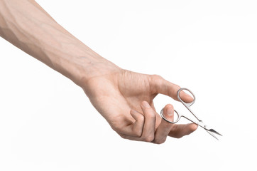 Hand holding scissors for manicure isolated on white background