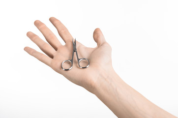 Hand holding scissors for manicure isolated on white background