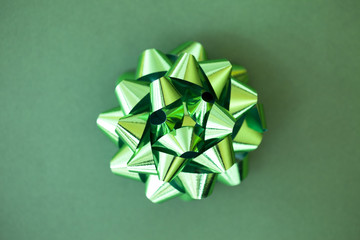 Overhead close-up view of a Green bow on a green background