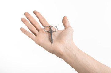 Hand holding scissors for manicure isolated on white background