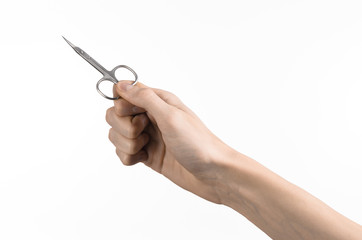 Hand holding scissors for manicure isolated on white background