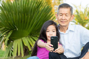 Grandfather and grandchild making self portrait with smart phone