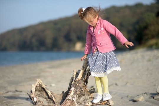 Girl (2-3) standing on log