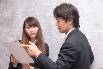 オフィスで指示を出す上司の男性と話を聞く女性