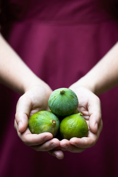 Woman holding 3 fruit