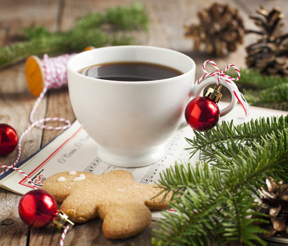 Cup of coffee and gingerbread cookie with christmas decorations