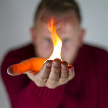 Close-up of a Man holding a fire in his outstretched hands