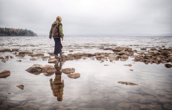 Sweden, Dalarna, Young girl (8-9) walking on stones at lake Siljan