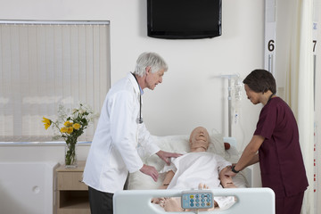Doctor with nurse examining cpr dummy